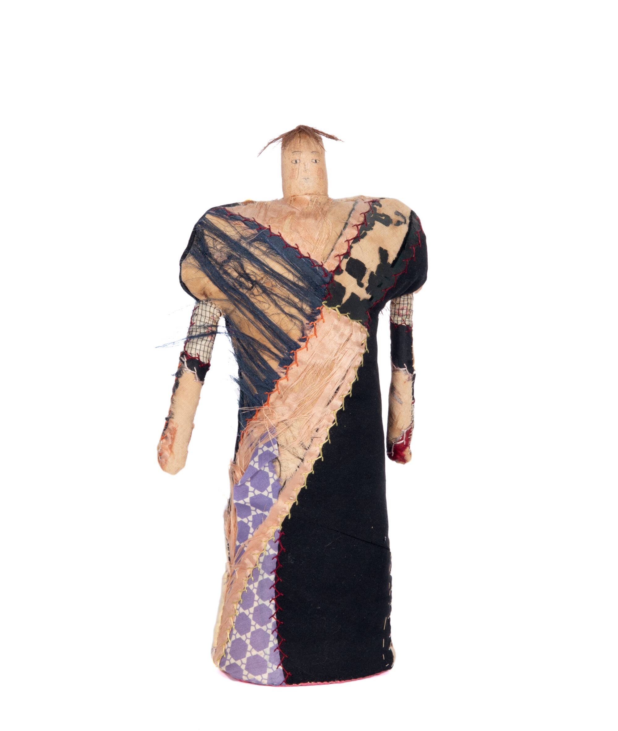 Soft-sculpture made of recycled textiles, looks like a doll wearing a dress.